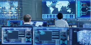在系统控制室，操作员和管理员坐在他们的工作站，有多个显示图形和物流信息的显示器。