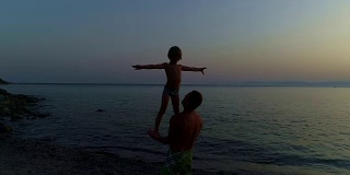 父亲和儿子在日落海滩上玩耍