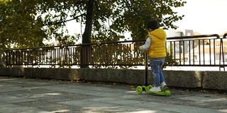 蹒跚学步的小男孩骑滑板车