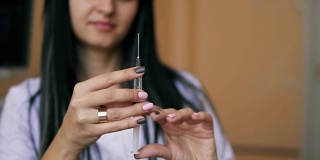 注射器在注射前被检查的特写。年轻女性褐发医生准备注射器注射。Slowmotion拍摄