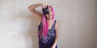 摄影师女孩与粉红色的头发为照片拍摄