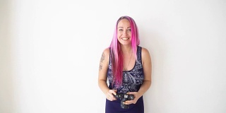 粉色头发的女孩用老式相机拍照