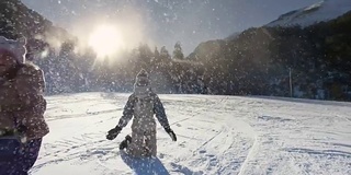 孩子们在雪地里玩耍，背景是夕阳