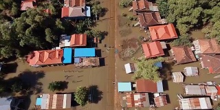 在一个乡村里，人们在被洪水淹没的街道上行走