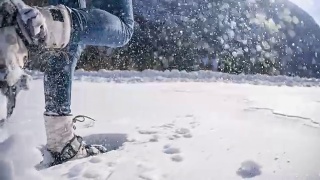 在白雪覆盖的山坡上穿雪鞋的女人视频素材模板下载