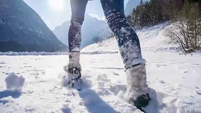 在新雪上穿雪鞋的女人