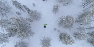 空中女孩冬天在雪山上用新雪制作雪角