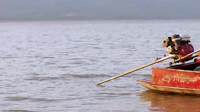 亚洲女渔民正在驾驶一艘船捕鱼