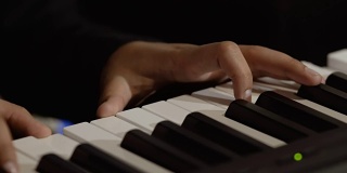 男性的手在钢琴上弹奏旋律