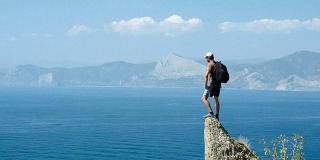 一位游客在悬崖顶上审视着风景