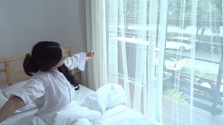 亚洲年轻女子在卧室醒来视频素材模板下载
