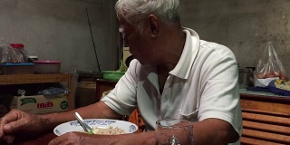 老人在吃米饭