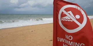 4 k。海滩上的安全信息禁止游泳标志。红旗警告说，这一地区的水是禁止进入的。游泳的环境不安全。