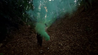 人在森林中持有绿色烟雾- 4K分辨率视频素材模板下载