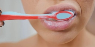 女人用牙膏和牙刷清洁牙齿