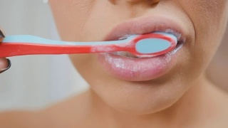 女人用牙膏和牙刷清洁牙齿视频素材模板下载