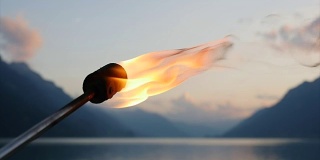 年轻的白人男子玩着燃烧的火炬。吃火者，喷火者在夜间使用火焰。