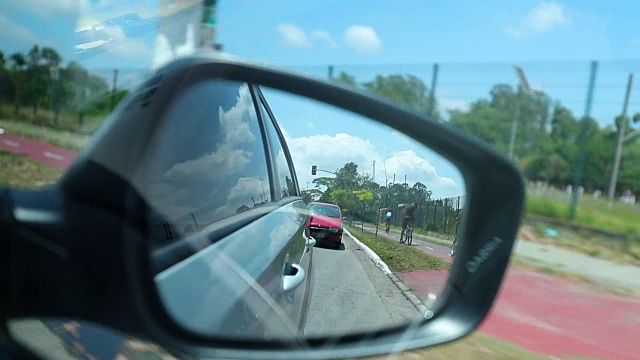 从汽车后视镜中看到的道路。慢镜头120fps拍摄后视镜