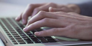 记者或作家使用现代科技在笔记本电脑上打字工作