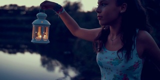 一个年轻女子拿着灯笼探索大自然的慢动作镜头