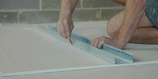 工人在一块石膏板上做标记，准备安装在新建的房子里。