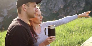游客们在群山的背景下喝着热水瓶里的茶