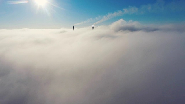 鸟瞰图。在雾中飞翔，在雾中飞翔。航空摄影机镜头。飞越云层，向着太阳。多雾的天气，从上面看。