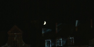 夜晚，半月在屋顶上闪耀