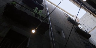 斯坦尼康镜头拍摄:在巴塞罗那的哥特式地区带阳台的房子。巴塞罗那狭窄街道上的老房子的正面。旅行的概念。慢动作