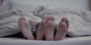 睡在一起的年轻情侣的脚