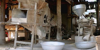 在农村地区使用老式大米处理机的老式木制托盘
