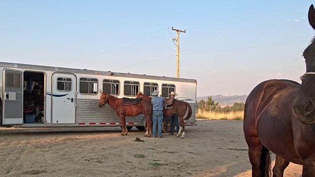 两个牛仔准备他们的马骑马在犹他州，美国