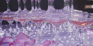 金字塔状的玻璃上放着香槟，花瓣飘落