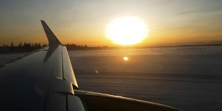 近距离观察:日出时分，飞机在芬兰的雪地上降落时的机翼
