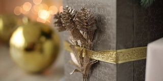 时尚的白色内饰手工礼品和礼物装饰丝带和凸起的圣诞树。温馨的家满是金色的装饰品、彩灯和花环
