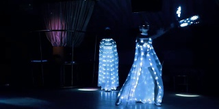女孩们穿着白色LED的服装，带着LED风扇热情地跳舞