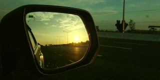 从侧镜看高速公路上的夕阳