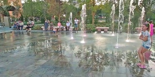 孩子们在斯坎德培广场的喷泉里玩水