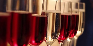 有酒精饮料的杯子，葡萄酒和香槟的杯子在自助餐桌上，红酒在玻璃杯里，香槟在玻璃杯旁边，在餐厅里有酒精的自助餐桌子，新年，圣诞节