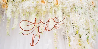 书写的动画保存日期书法文字与华丽的框架元素的婚礼拱门与白色和粉红色的花。复古和金银丝装饰。金银丝分配器婚礼请柬