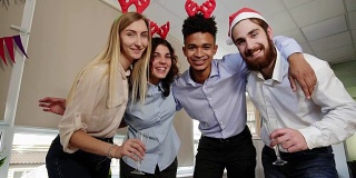 快乐的商业人士戴着圣诞帽在办公室里自拍，看着相机微笑着庆祝新年。Slowmotion拍摄