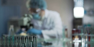 科学家在实验室检查病人血液样本前调整显微镜