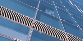 城市摩天楼商业中心在巴塞罗那。办公大楼上现代建筑窗户的几何形状细节。摩天大楼的天空背景。看了。底部视图。多莉拍摄