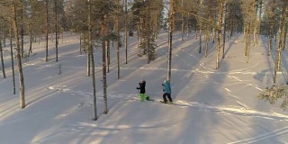 天线:活跃的夫妇在温暖的冬天穿着雪鞋在厚厚的雪地上徒步旅行