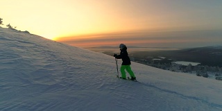 天线:冬季日出时，活跃的女性穿着雪鞋在雪坡上徒步