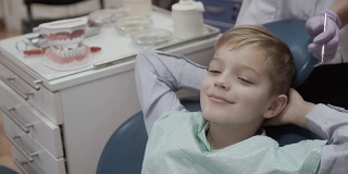 快乐的小男孩坐在牙医椅上