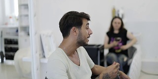 一名年轻的土耳其男子主持了一场大师班，谈论着染发的当前趋势。