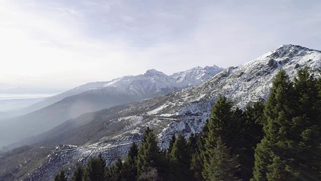在冬季，无人机飞行建立在雪山森林之上。雪山在户外自然。旅行探索阿尔卑斯山。4k建立视频