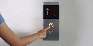 女人按电梯按钮。