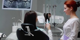 牙医和病人一起完成了他的工作。移除Bor机器，并给一个女孩一面镜子来评估工作。女孩看着你的牙齿，感谢牙医